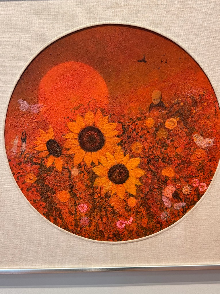 a painting of a field of sunflowers with children and butterflies subtly added into the background; the following was on the plaque next to the painting: 

Walter H. Williams, Jr.
United States, 1920-1998
Untitled (Sunflower Field)
1971
Oil and sand on Masonite
Gift of Dr. James and Vivian Curtis, 2025/1.119
After serving in an all-Black unit of the U.S. Army during World War II (1939-45), Walter H. Williams returned home to New York, where he trained with notable modernists including Ben Shahn (1898-1969) and David Driskell (1931-2020). Williams exhibited at the Whitney Museum of American Art in New York City, taught at Fisk University in Tennessee, and won multiple fellowships to travel abroad before moving permanently to Denmark in the mid-1960s. In 1964, he organized an exhibition in Copenhagen called Ten American Negro Artists Living and Working in Europe featuring fellow artists seeking respite from racial prejudice.
Williams often painted children playing in dreamy landscapes, where butterflies and birds embody freedom, and sunflowers radiate happiness. These vibrant compositions are also marked by darker elements such as uprooted trees, a caged bird, or the serious gaze of a young child, hinting at the solemn realities from which these imaginary scenes take flight.